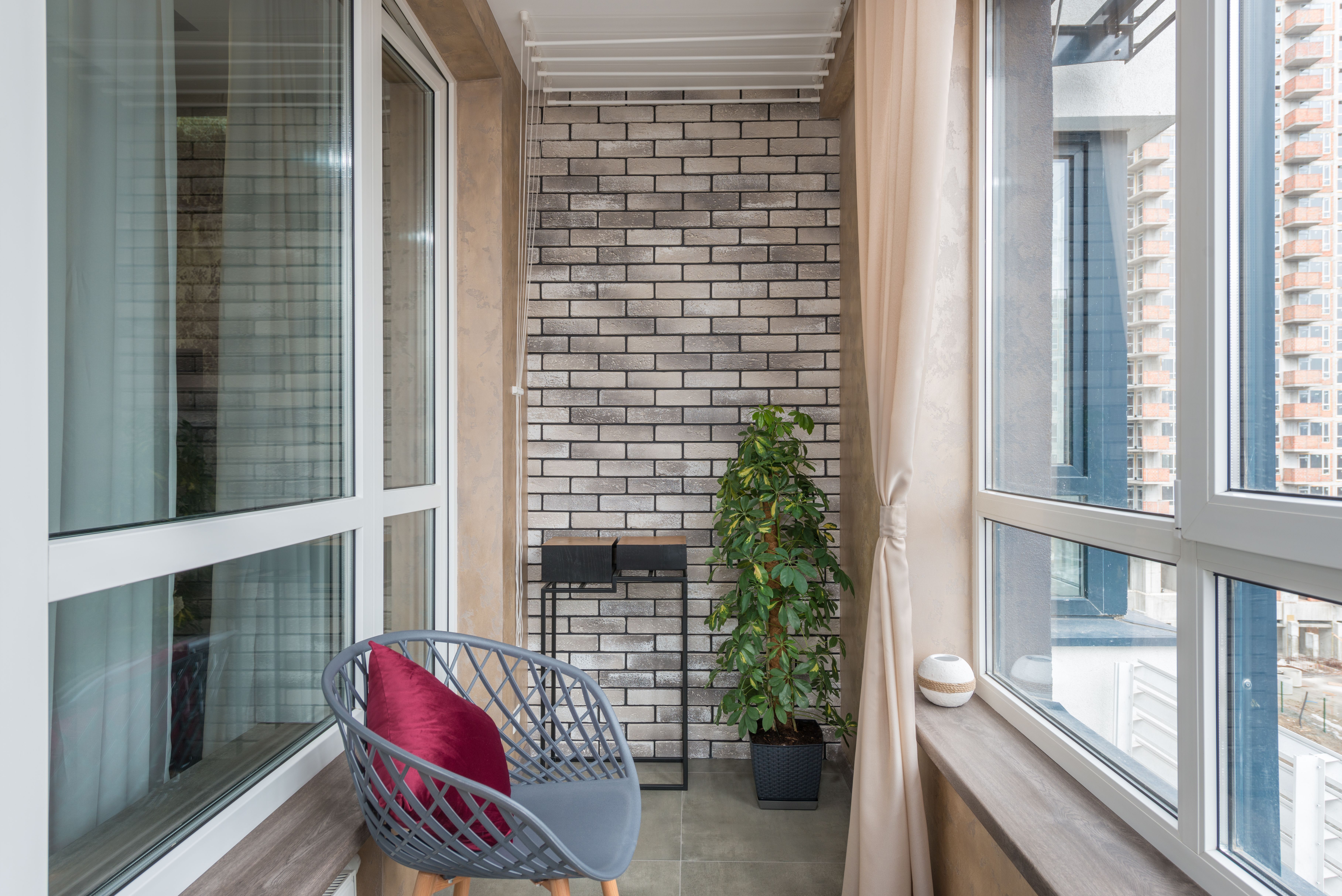 Chair with soft cushion and potted plant on a spacious modern apartment patio